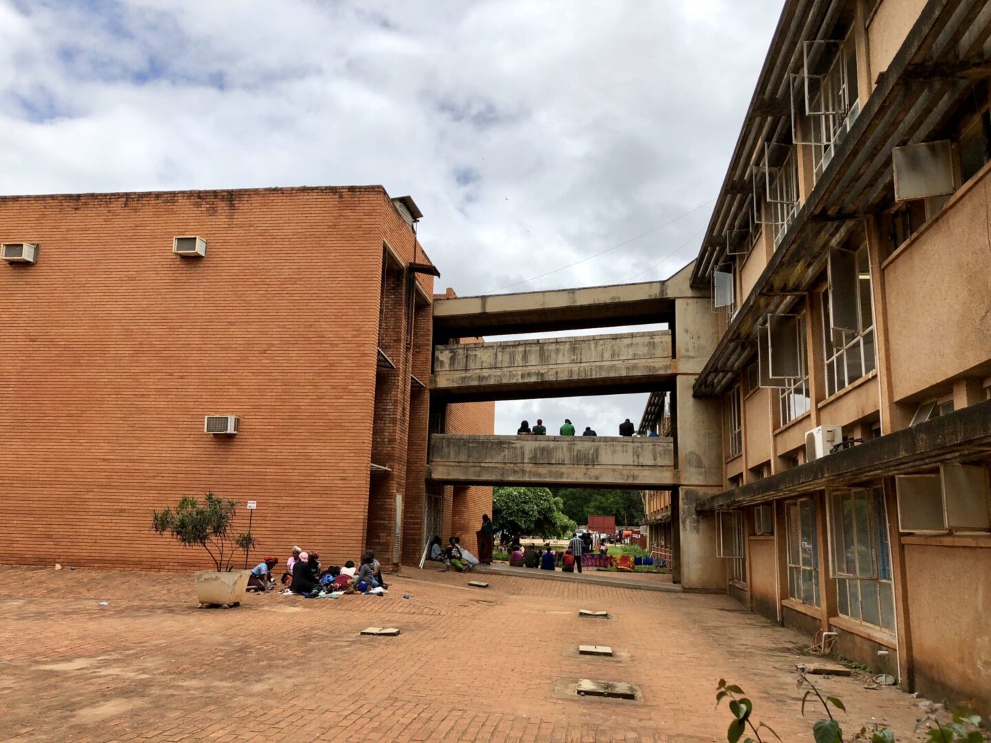 A building with people sitting on the ground.